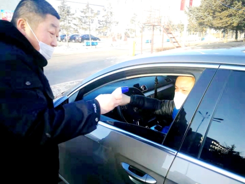图为东荣二矿保卫科干警严格检查进出矿车辆，，，，，对每名进矿职工都进行体温测量并登记。。。。。。。