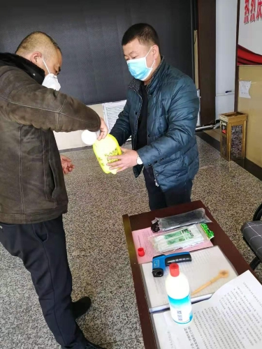 七台河公司东风矿矿党委副书记王占寒在督导检查防疫工作的同时为单位提供测温仪、消毒液、喷壶等防护用品。。。。。。图为王占寒（左）正与党员对办公场所进行消毒。。。。。。（于秀娟摄）